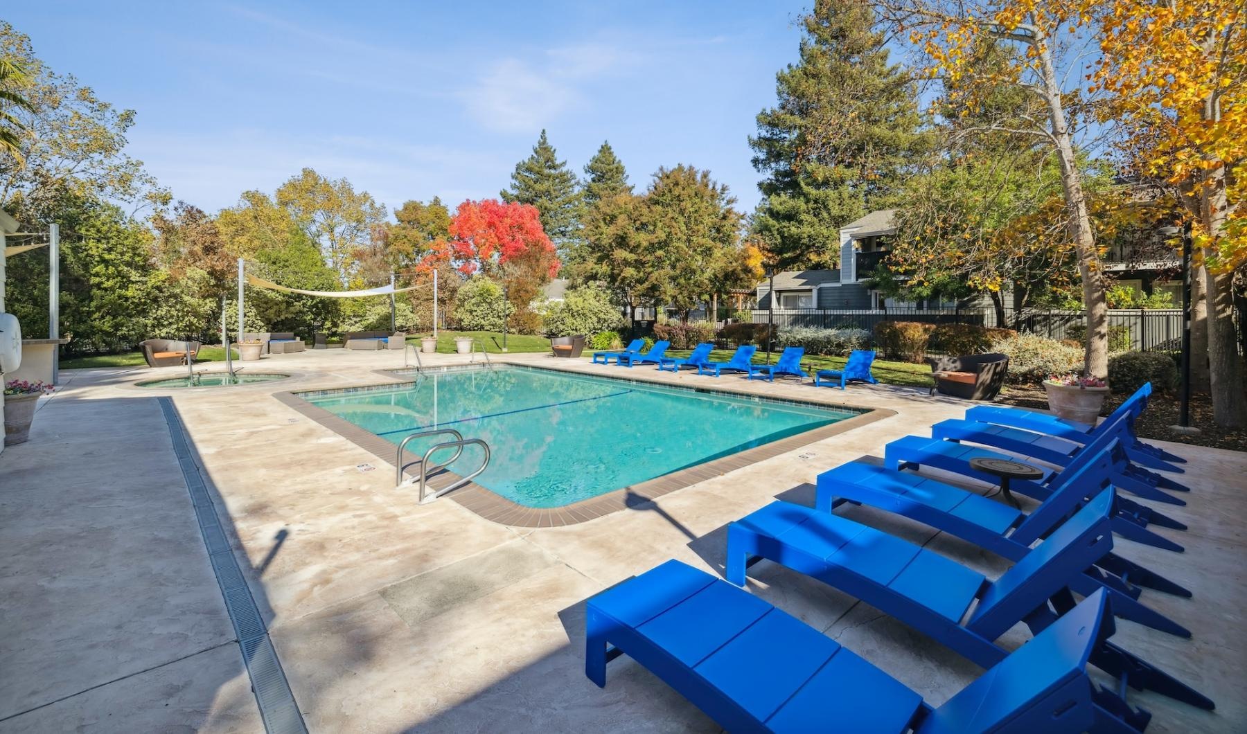 a swimming pool with blue chairs