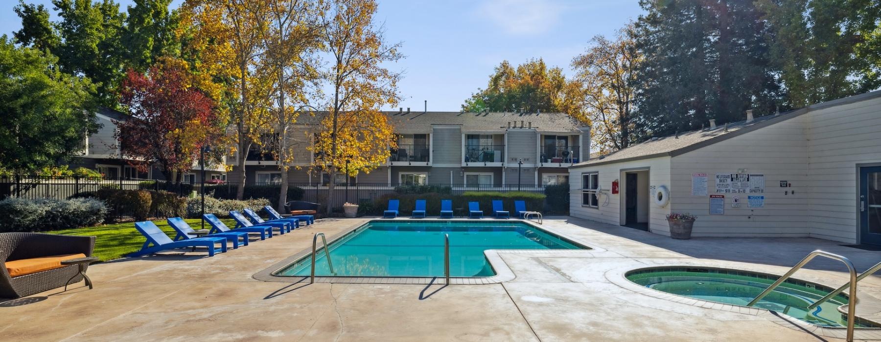 a swimming pool and hot tub behind a building
