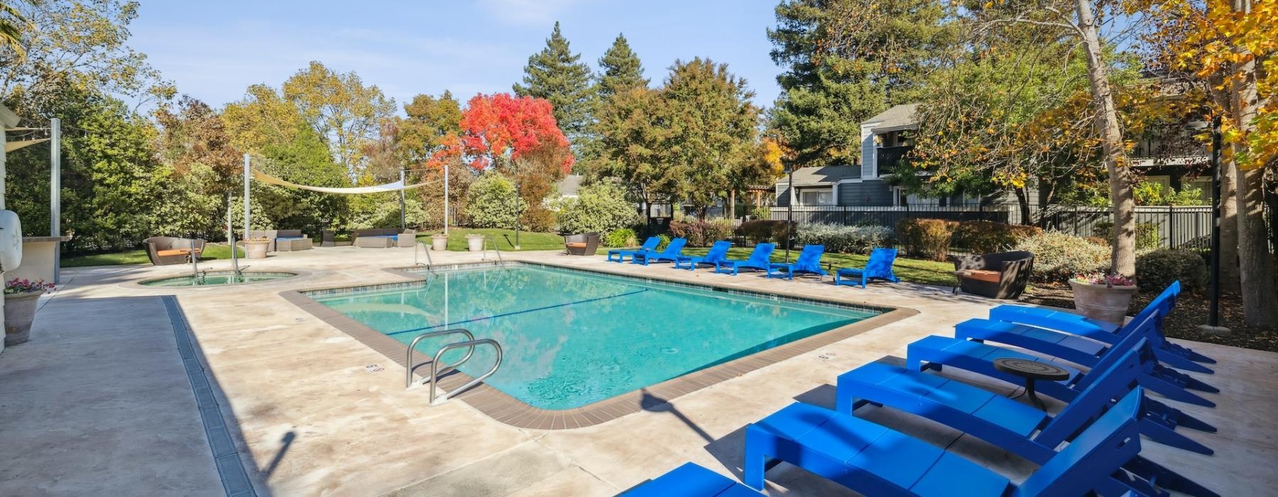 a swimming pool with blue chairs